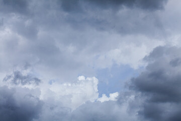 Blue spot of sky appearing through cloudy grey sky after rain