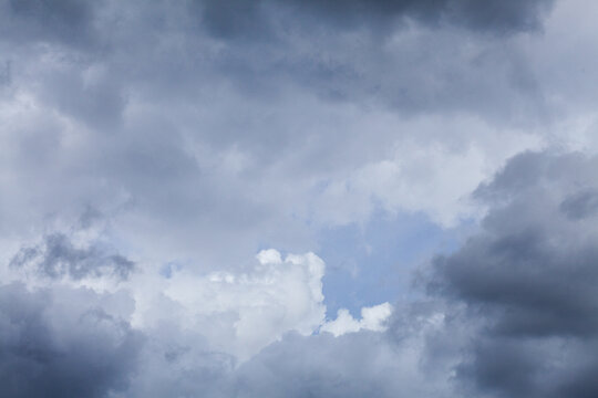 Blue spot of sky appearing through cloudy grey sky after rain