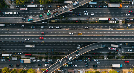 An overhead view shows a busy highway interchange with many cars and trucks moving in different directions