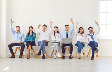 Group of business people raising hands to ask questions during an office meeting. Team working together, showing active participation, collaboration, and communication in the business environment.