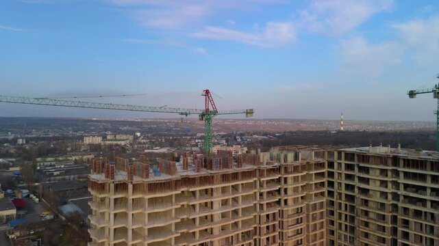 Large construction site with tower cranes and unfinished high-rise buildings