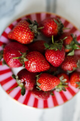 Red ripe strawberries on plate close up top view. Healthy eating.