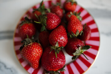 Red ripe strawberries on plate close up top view. Healthy eating.