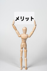 メリットのカードを持ったデッサン人形