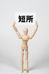 短所のカードを持ったデッサン人形