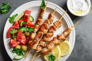 Grilled chicken kebabs with fresh vegetable salad and tzatziki sauce