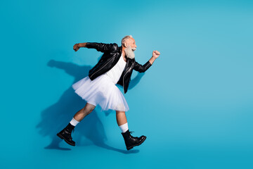 Obraz premium Photo of old man run fast wear dress skirt isolated on blue color background
