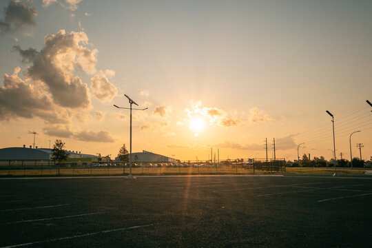 Sun setting over empty car park with solar street lights