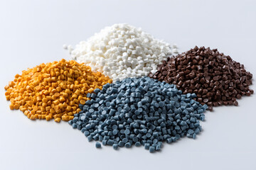 various colors of masterbatch plastic granules arranged on a white background, Polymer plastic beads resin polymer in white, yellow, brown and grey