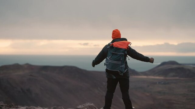 Man Standing on Cliff Overlooking Vast Icelandic Landscape