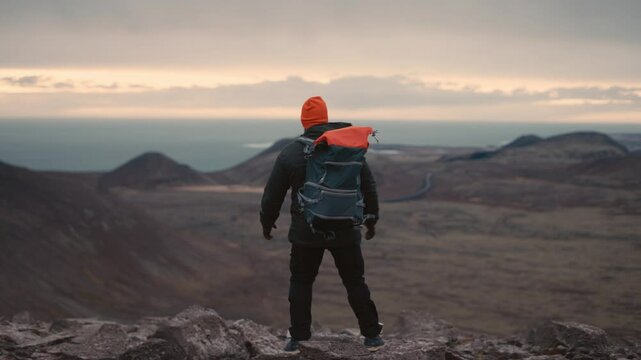 Man Standing on Cliff Overlooking Vast Icelandic Landscape