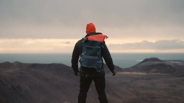 Man Standing on Cliff Overlooking Vast Icelandic Landscape