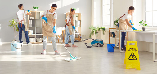 Dedicated cleaning service staff group cleaning home or office, including mopping, vacuuming, and dusting. Expert team of cleaners ensures a thorough and efficient cleaning process.