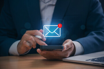Digital marketer using email marketing tools on laptop and smartphone, sending newsletters and...
