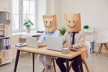 Creative business team working at laptop in office wearing paper bag with smile face, doing design project, planning happy ideas, brainstorming, busy at monitor, office employees at computer desk