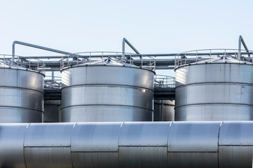 Industrielle Großbehälter in einem produzierenden Werk, die durch Rohrleitungen verbunden sind