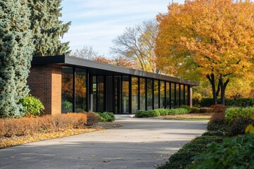 Contemporary architecture stands in striking contrast to the vivid hues of autumn leaves, creating a serene atmosphere in a tranquil garden on a sunny fall day