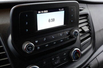 Center com controls of radio, LCD screen, and climate control inside a vehicle.