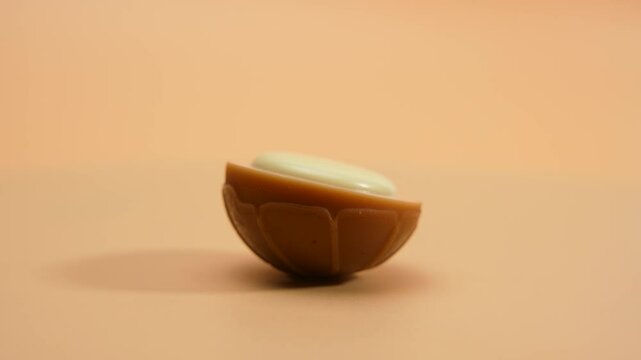 White chocolate candy rotates on an orange background. White chocolate toffee on orange background.