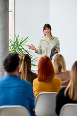 Confident Woman Speaking to an Engaged Audience During a Business Presentation Meeting