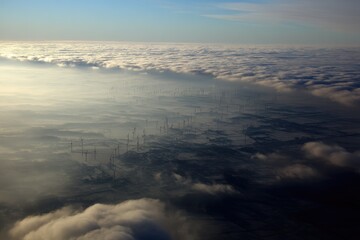 Aerial view of wind farm through clouds