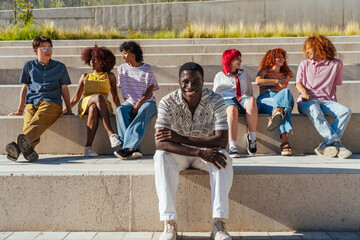 Obraz premium Multiethnic group of young friends meeting and having fun outdoors - Multiracial happy and stylish teen students bonding in the city, concepts about youth, teenagers lifestyle and diversity