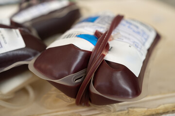 Plastic bags filled with blood, featuring labels, tubes, and details for medical use. Represents...