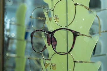 Stylish eyeglasses on modern display stand, elegant eyewear selection in optical store, close-up of...