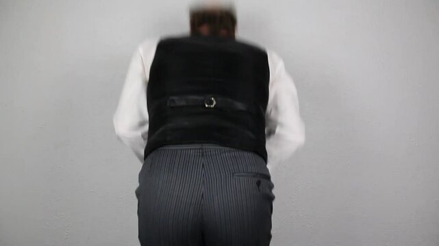 Servant in Waistcoat and White Gloves Repeatedly Punching Himself in the Stomach. Concept of Oof and Lower Class Abuse.