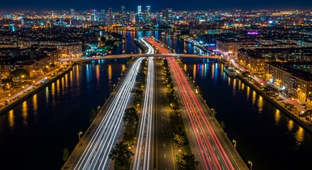 Fototapeta premium The city night view showcases a bridge over the river with traffic lights illuminating the urban cityscape