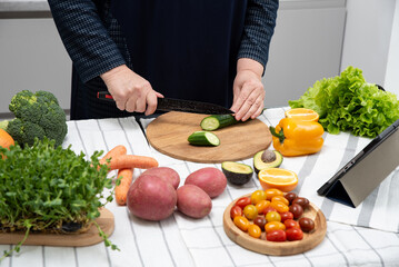 chubby woman cooking online recipe with tablet close up. Meal time