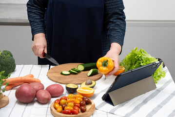 fat woman cooking online recipe with tablet close up. Meal time