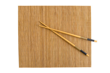 Bamboo placemat with wooden chopsticks positioned neatly on top. Dining setup perfect for Asian...