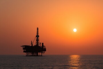 Obraz premium offshore oil rig silhouetted against clear sunrise reflecting economic prowess in vast ocean