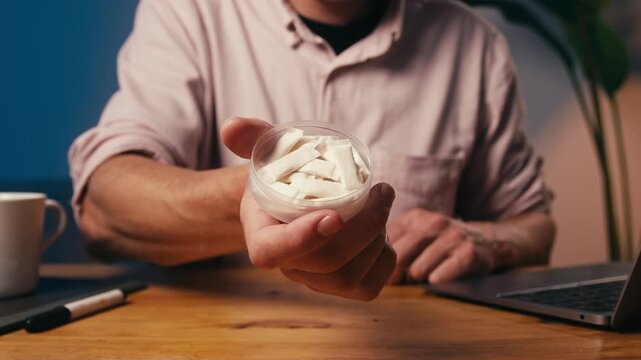 Snus nicotine tobacco close up, pack of tobacco for gum. unhealthy addiction. Man opening box with snus and taking one. 