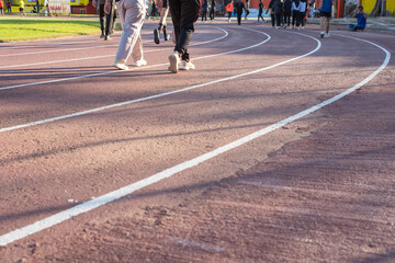 People walking on an outdoor running track in the morning, casual fitness activity, healthy...