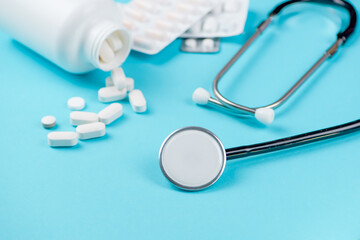 Stethoscope with heart and pills on color background. Health care concept