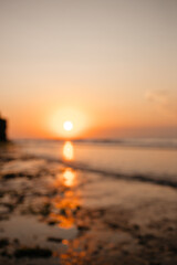 Fototapeta premium View of the orange sunset over the ocean is out of focus. Beautiful blurred background of nature and evening sky