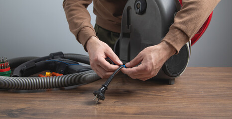 Caucasian master repairing vacuum cleaner. Vacuum cleaner repairing