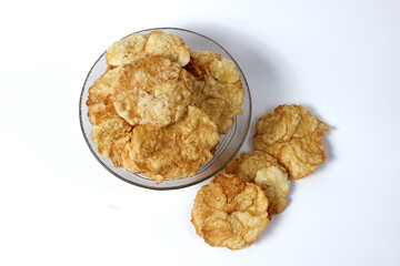 Sweet emping crackers food in a glass bowl isolated on white background.emping crackers are made from melinjo fruit. Traditional snacks from Indonesia