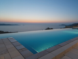 Fototapeta premium Elegant infinity pool at dusk with stunning ocean view and tranquil atmosphere in coastal setting