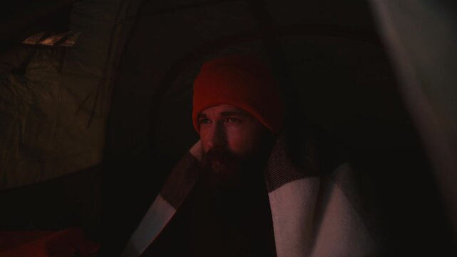 Cozy Camping Moment in Iceland: Man Enjoys Hot Tea Inside Tent
