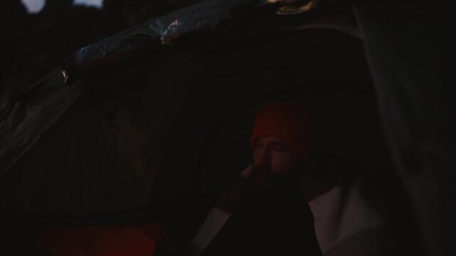 Cozy Camping Moment in Iceland: Man Enjoys Hot Tea Inside Tent