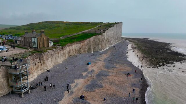 Busy Birling Gap in East Sussex, UK&mdash;showing iconic chalk cliffs, beach staircase, car park, and visitors. Great for travel, tourism, hiking, and coastal lifestyle commercial use
