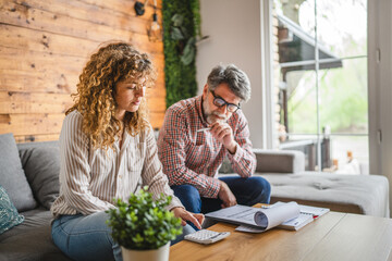 senior man and adult woman calculate household expenses