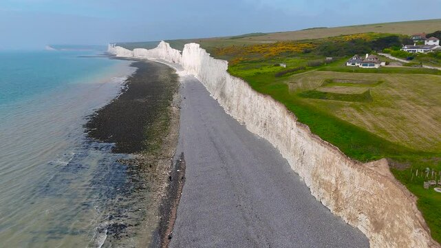 Busy Birling Gap in East Sussex, UK&mdash;showing iconic chalk cliffs, beach staircase, car park, and visitors. Great for travel, tourism, hiking, and coastal lifestyle commercial use
