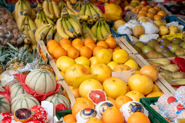A fruit stand with a variety of fruits including oranges, bananas, and pears