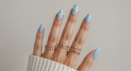 Close-up of Pastel Blue Oval Nails with White Floral Nail Art and Dainty Jewelry