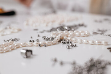 Small Business. A jewelry designer carefully crafting handmade accessories using beads, pliers, and metal parts. Close-up of hands creating elegant jewelry pieces	