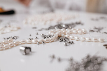 Small Business. A jewelry designer carefully crafting handmade accessories using beads, pliers, and metal parts. Close-up of hands creating elegant jewelry pieces	